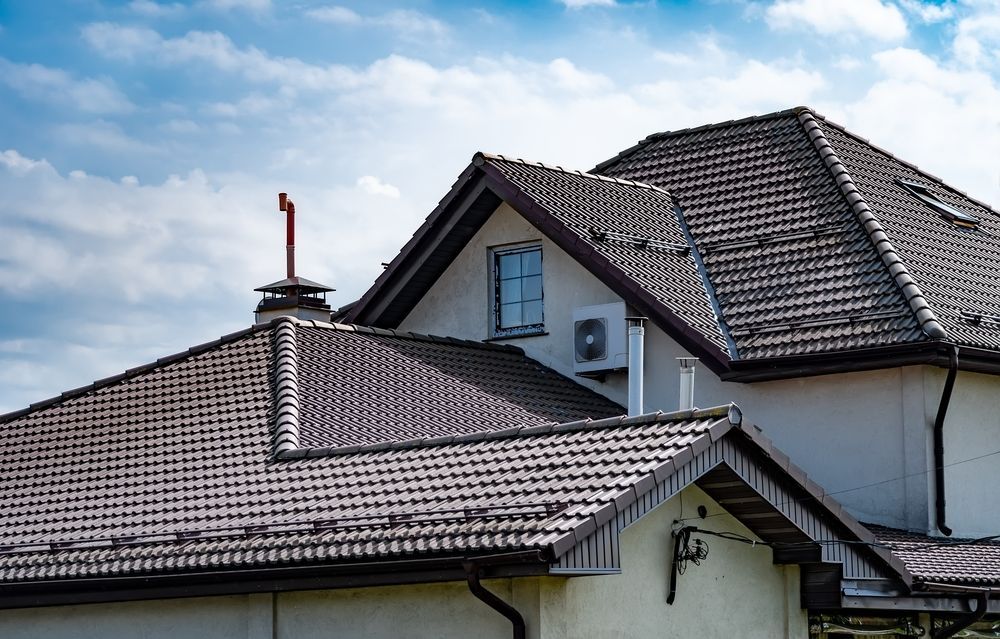 A house with a tiled roof and a chimney on top of it.