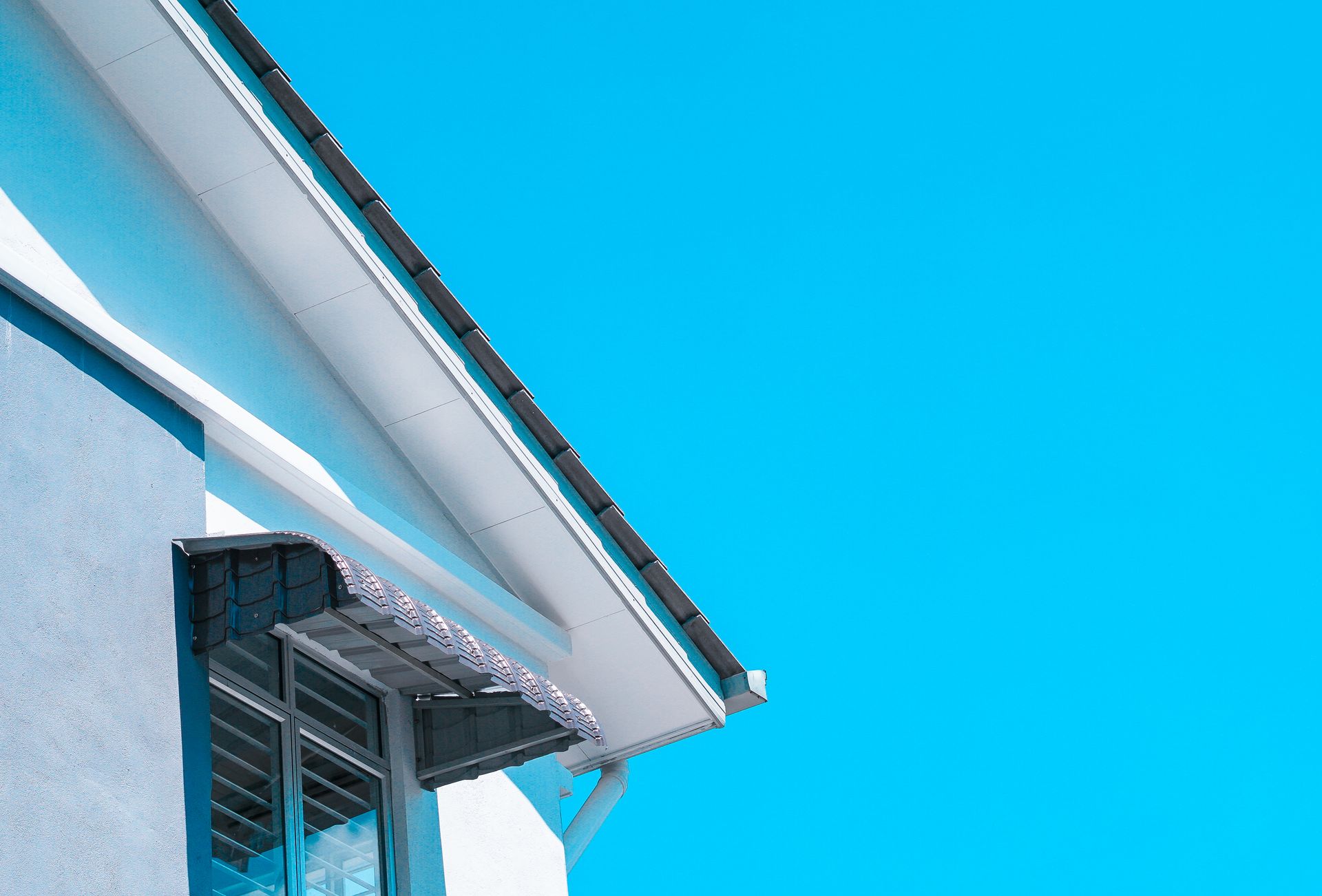 The roof of a house with a blue sky in the background.