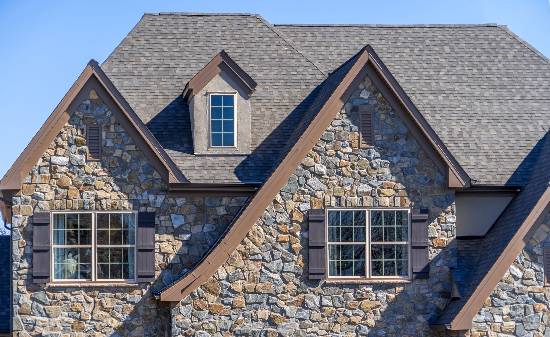 A large stone house with a gray roof