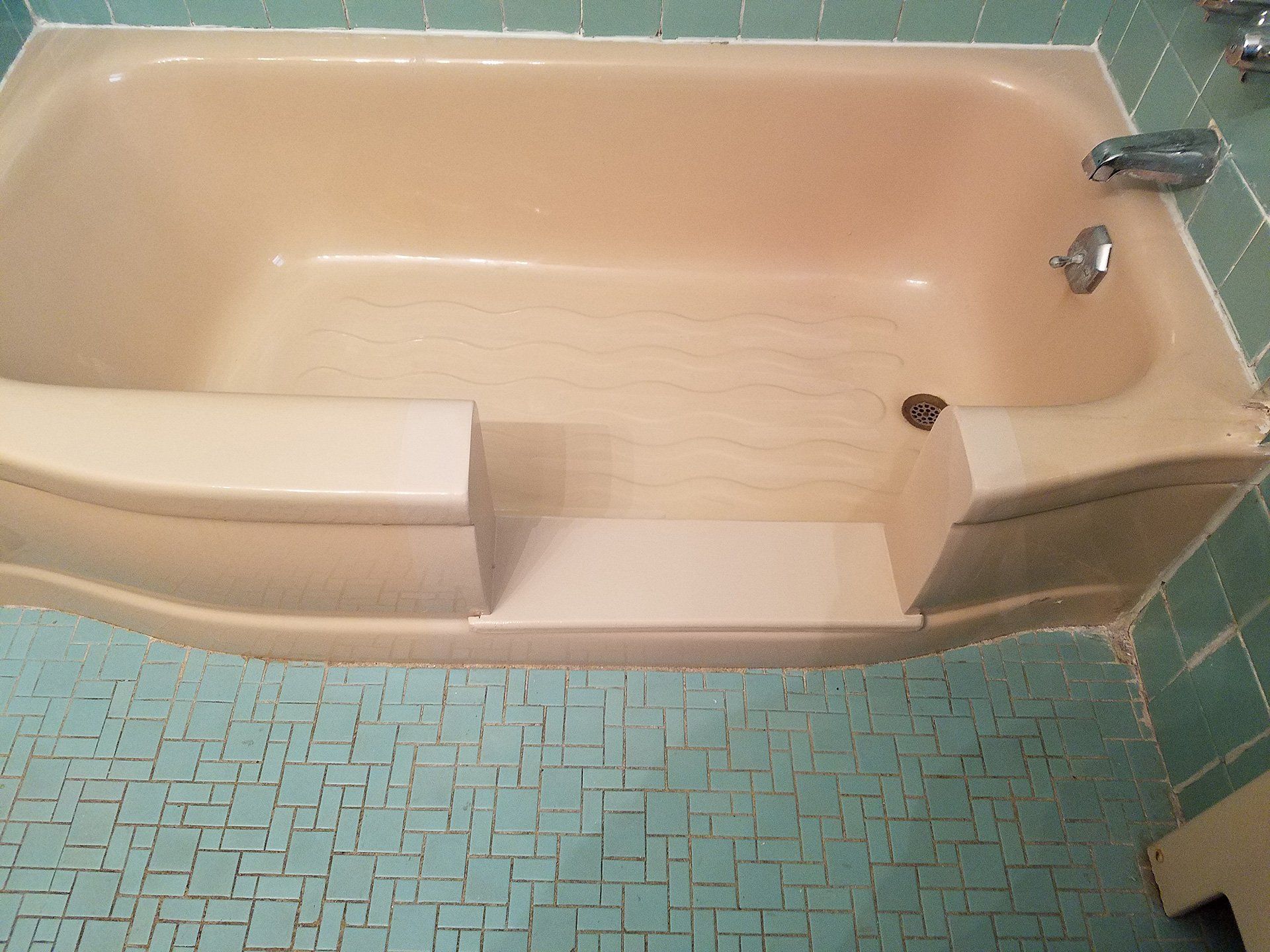 cut in the bath tub for with blue tiles in the babthroom
