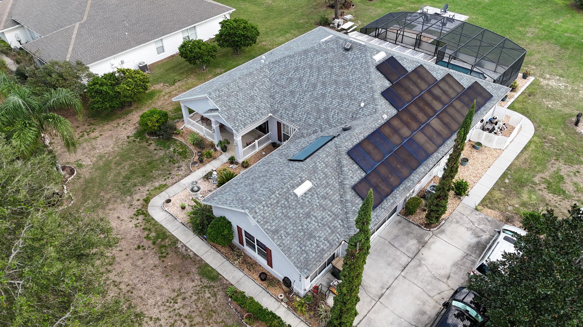 An aerial view of a house with solar panels on the roof.