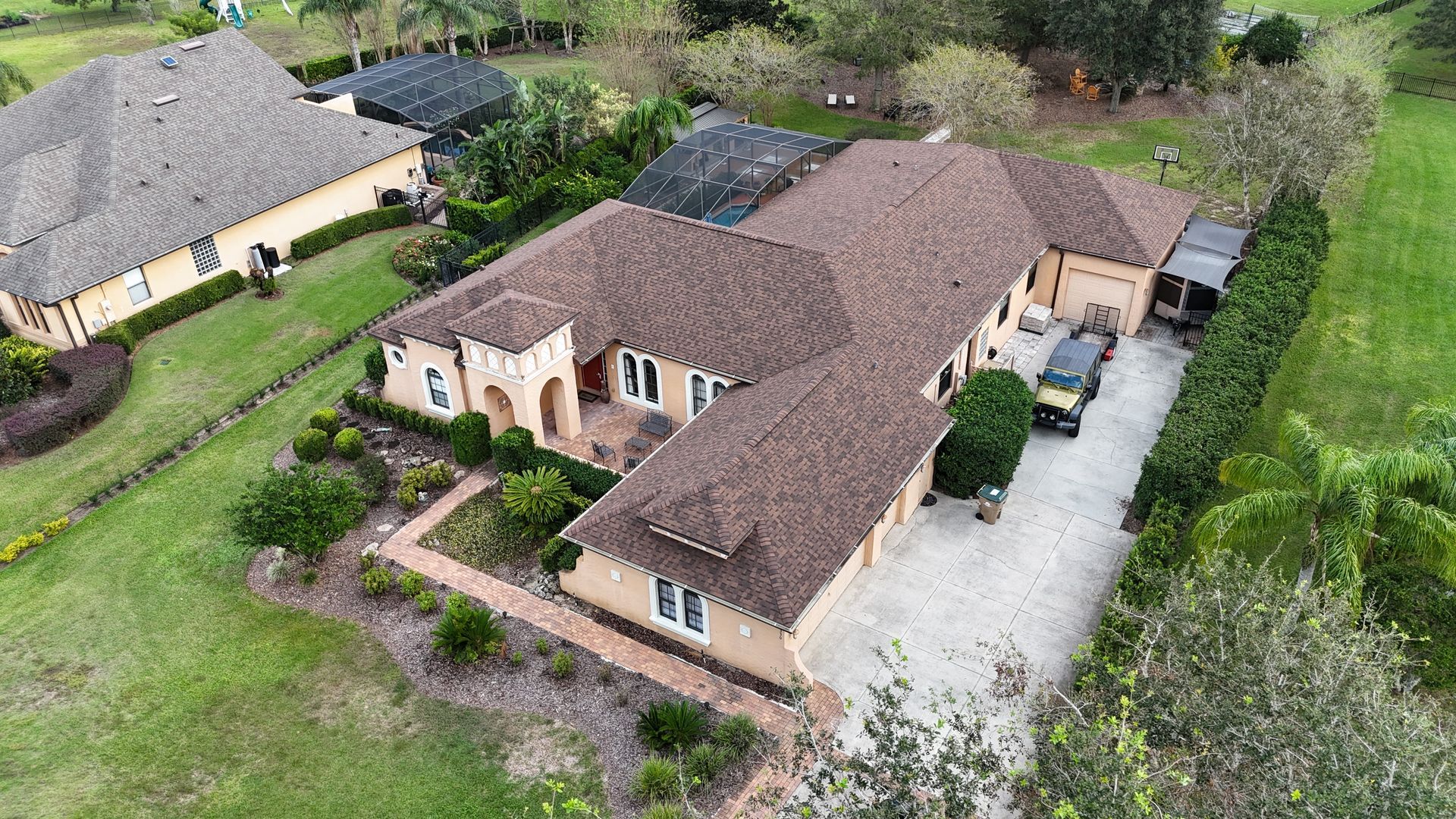 An aerial view of a large house with a car parked in front of it.