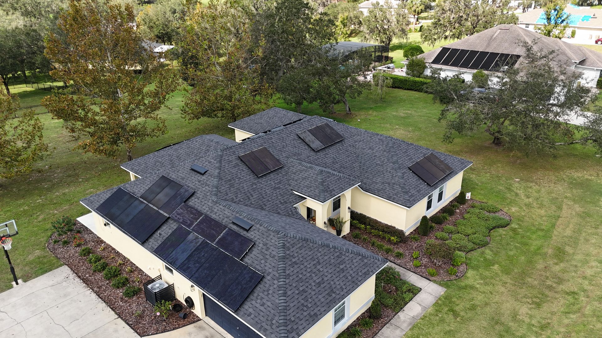 An aerial view of a house with solar panels on the roof.