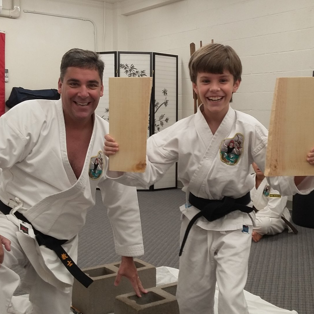 kid showing his karate chopped wood