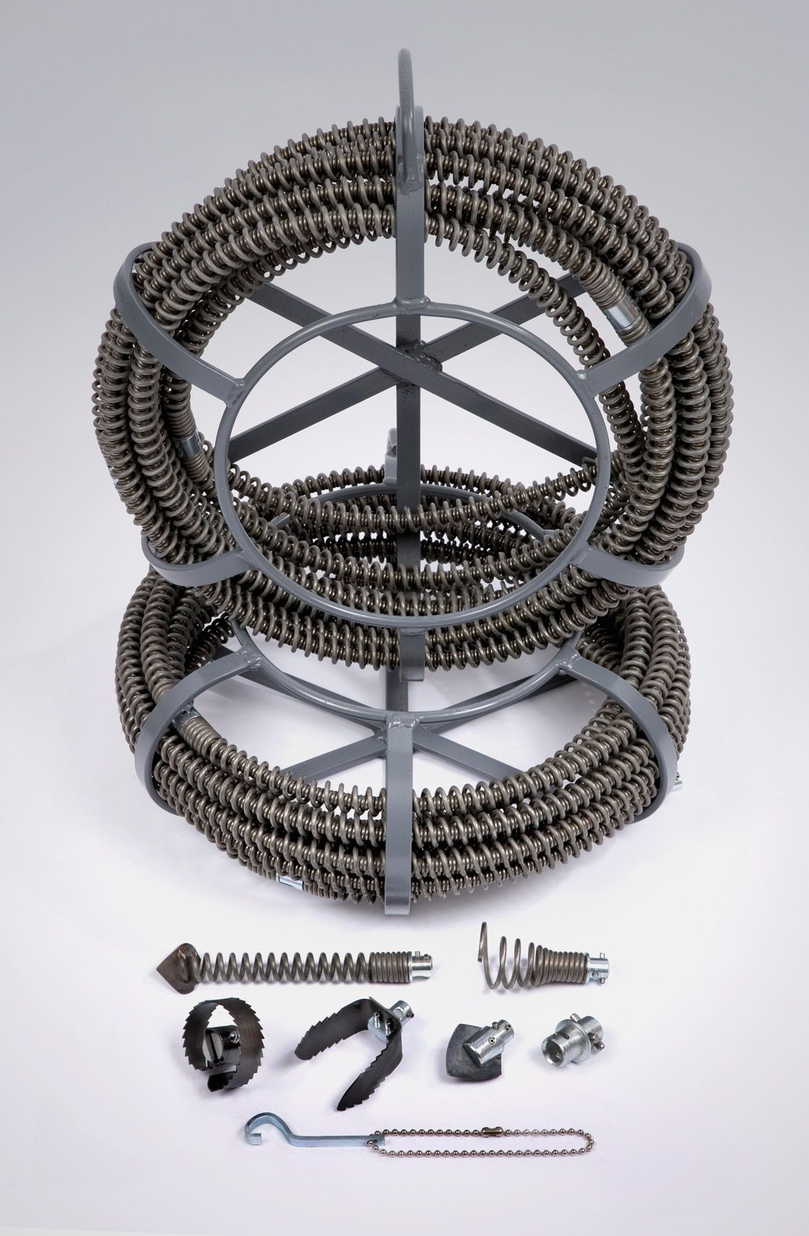 Drain cleaning snake and accessories. Two coiled snakes held in a gray stand with various attachments below.