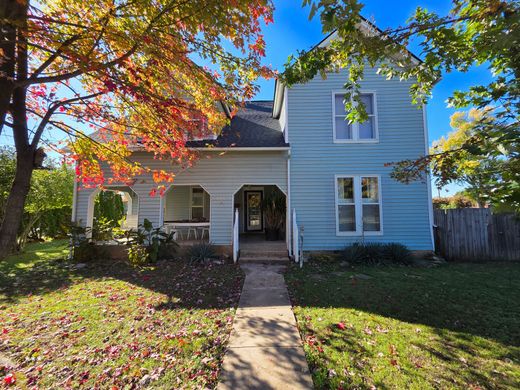Blue house with porch and autumn leaves.