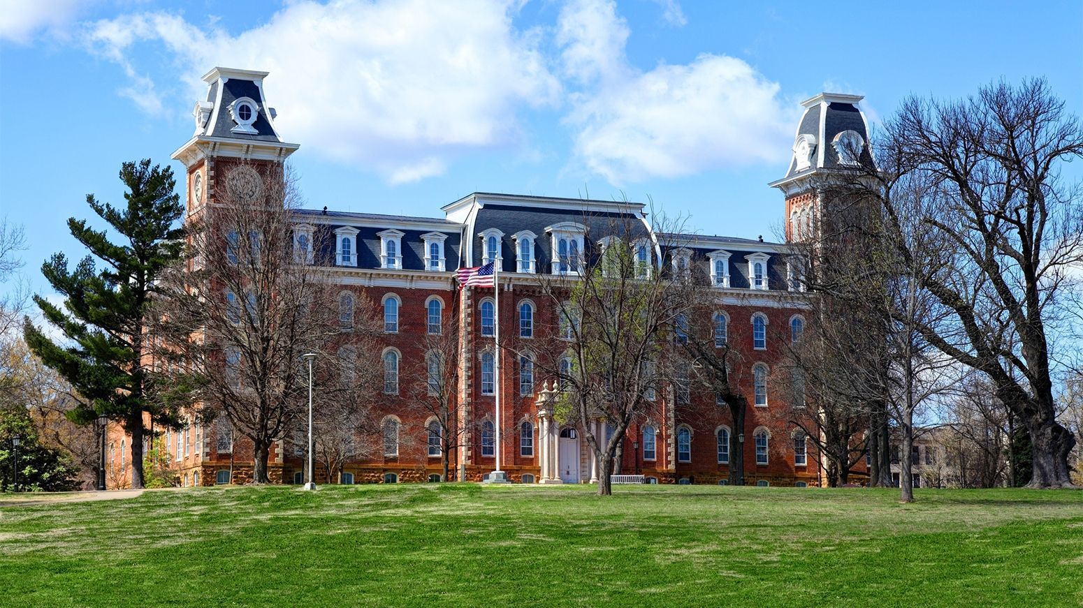 A large brick building with a flag in front of it