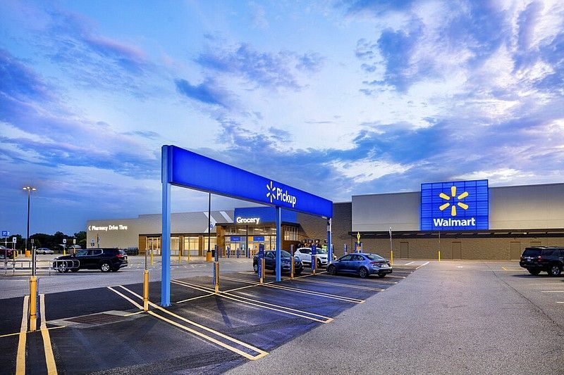 A walmart store with cars parked in front of it