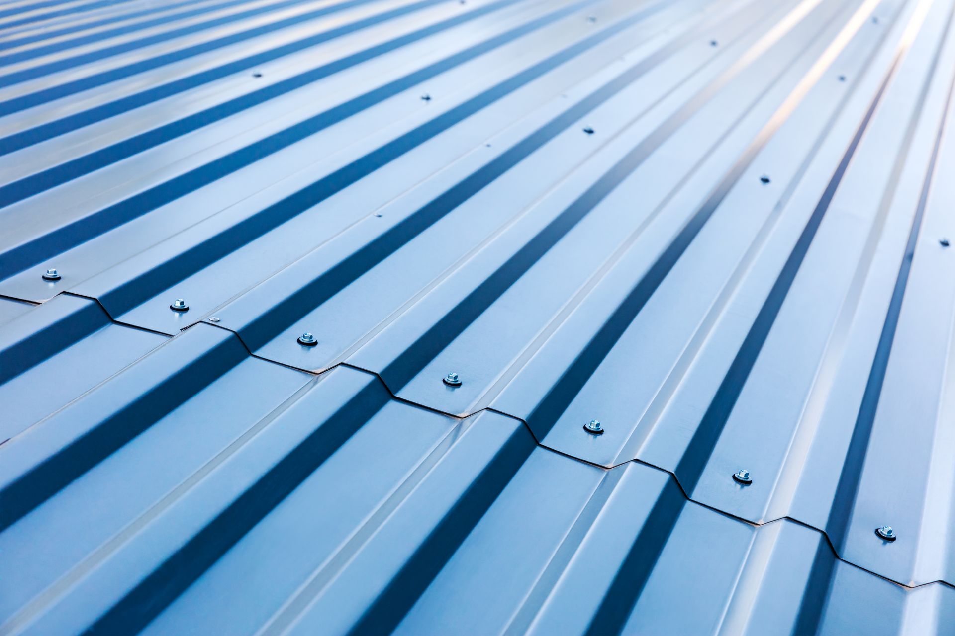 A close up of a metal roof with a blue sky in the background.