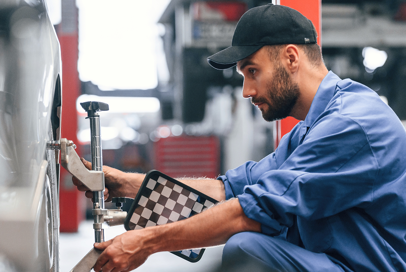 mechanic performing wheel alignment | Surprise Goodyear Car Care