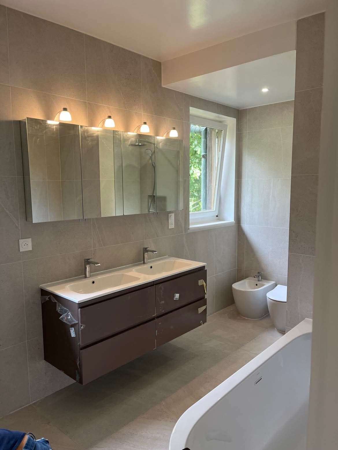 Une salle de bain avec lavabo, WC et miroir.