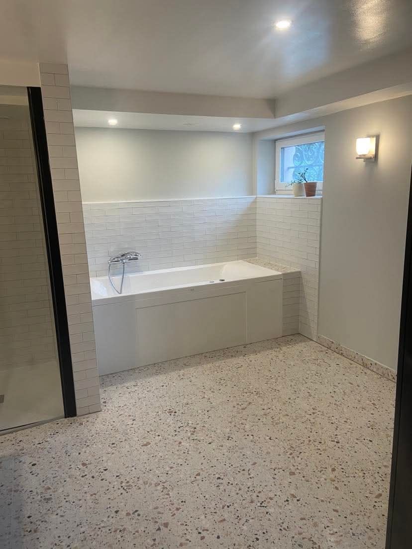 Une salle de bain avec toilettes, lavabo, douche et fenêtre