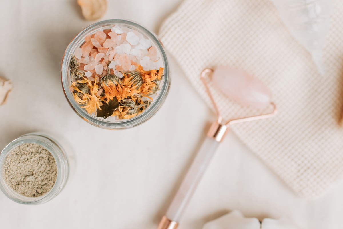 tongue scraper, powders, and herbs lay on a table