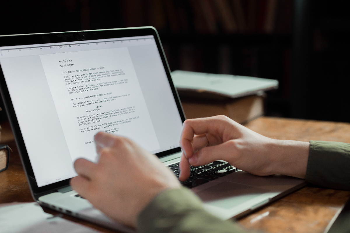 hands on a laptop writing an article 