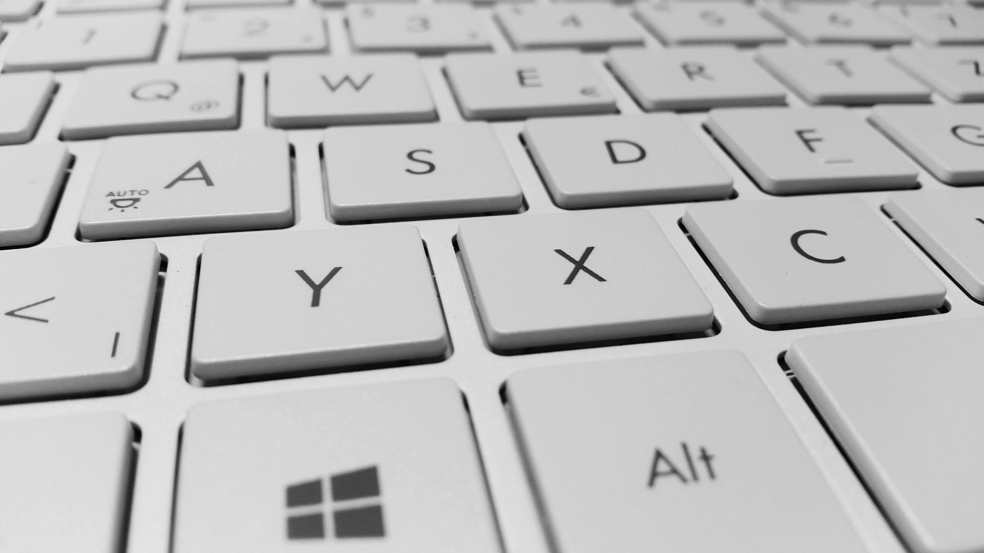 Close-up of a white computer keyboard featuring a QWERTZ layout and a Windows key.