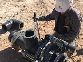 Worker Installing Poly Pipe in Midland, TX