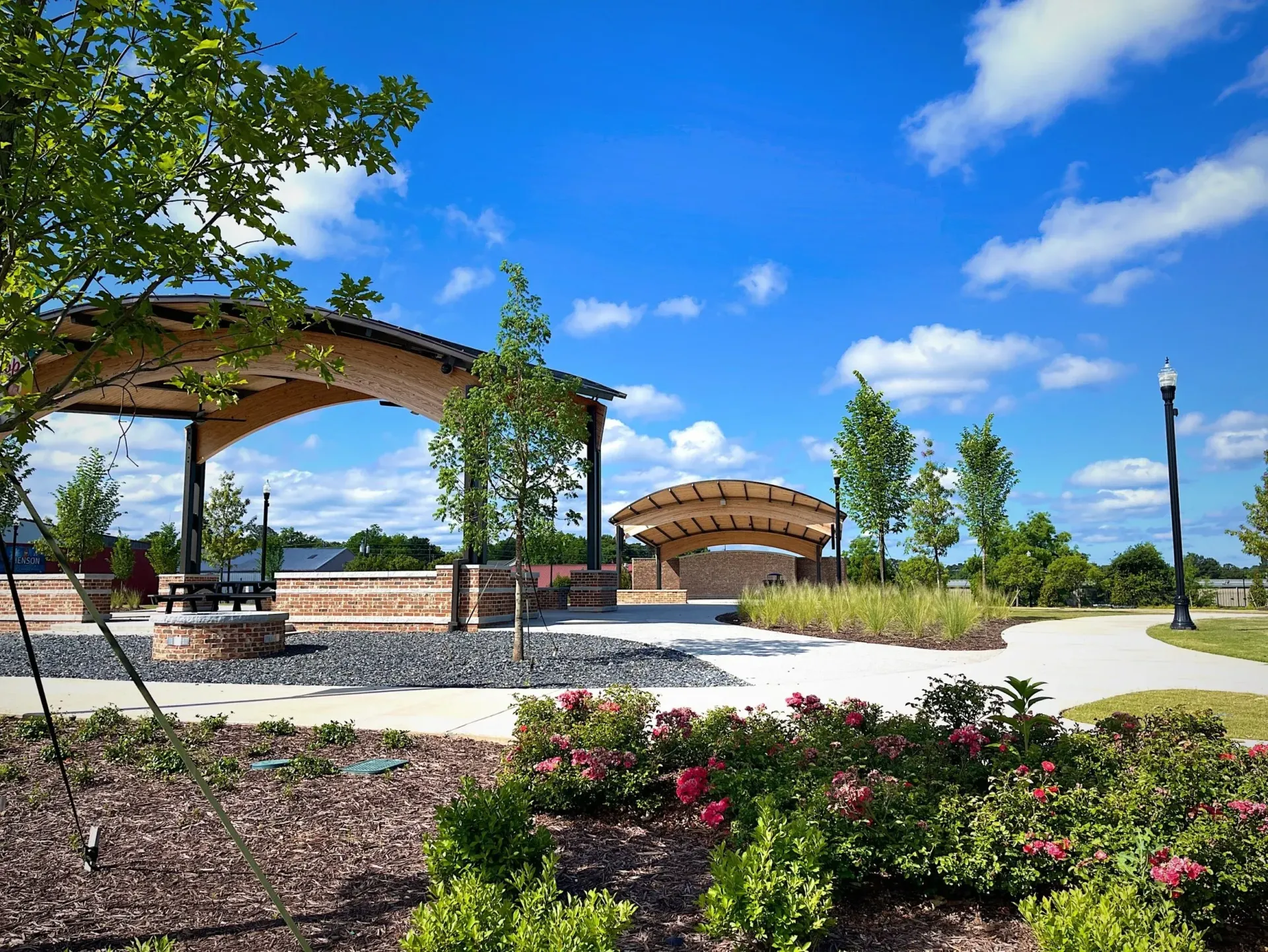 Park with covered structure, bridge, and landscaping under a blue sky. Commercial plumbers in Winder Georgia.