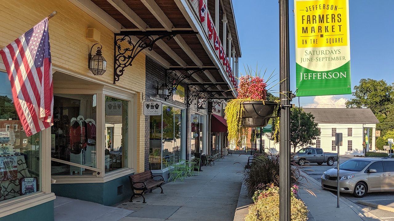 Street scene: shops with awnings, American flag, banner for