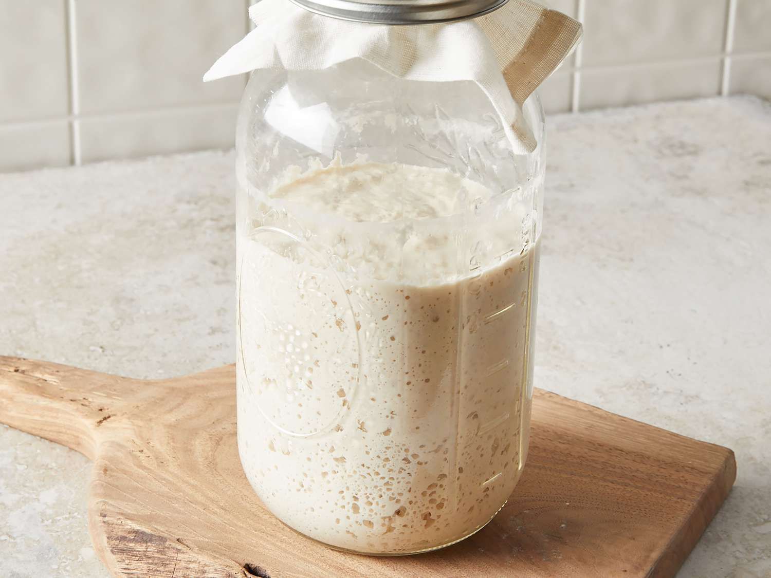 Sourdough discard in a jar on a counter. Sourdough discard can be harmful for your plumbing in your sink.