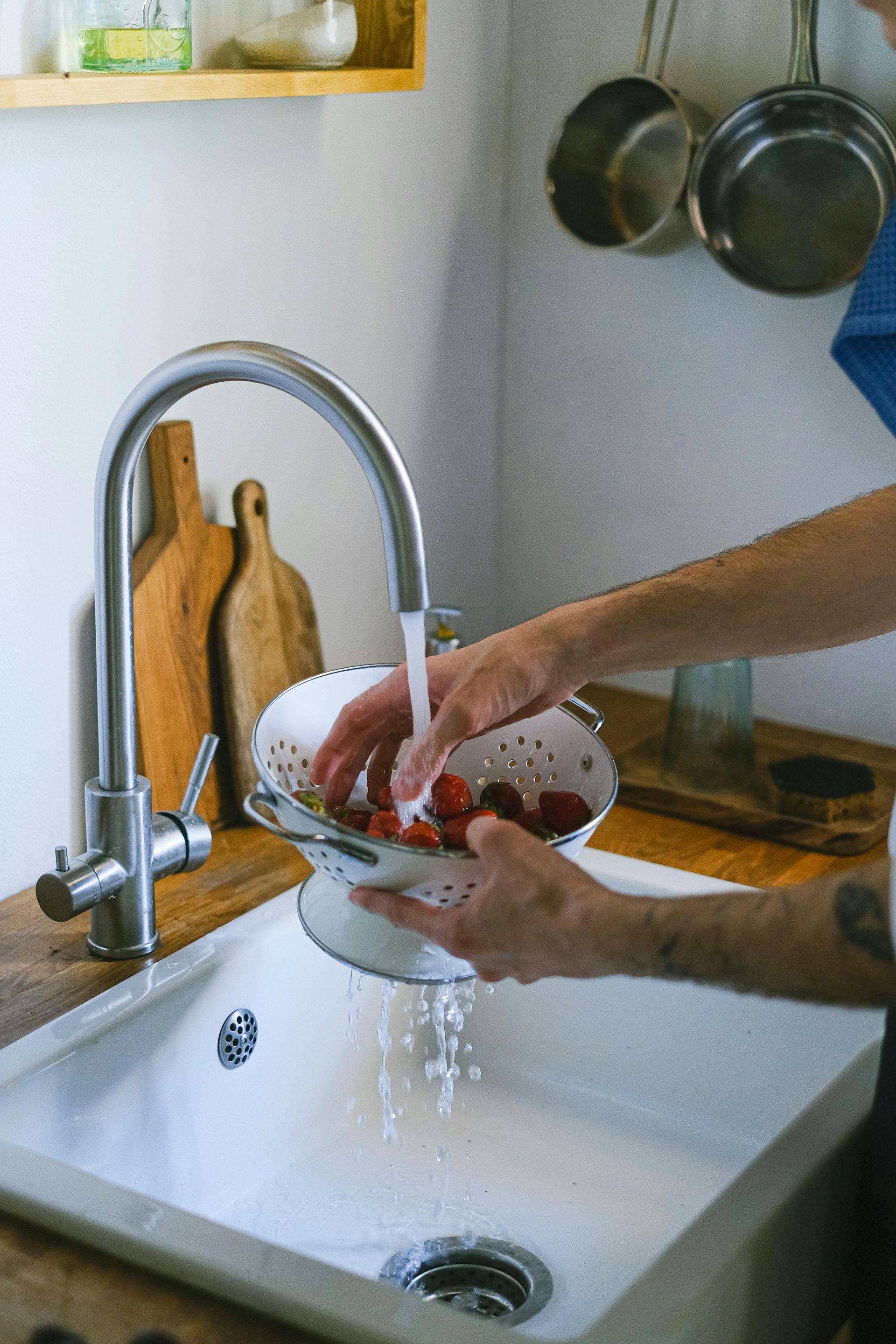 Rinsing fruit in a sink with a whole home water filtration system installed by MasterCraft Plumbing in Commerce Georgia