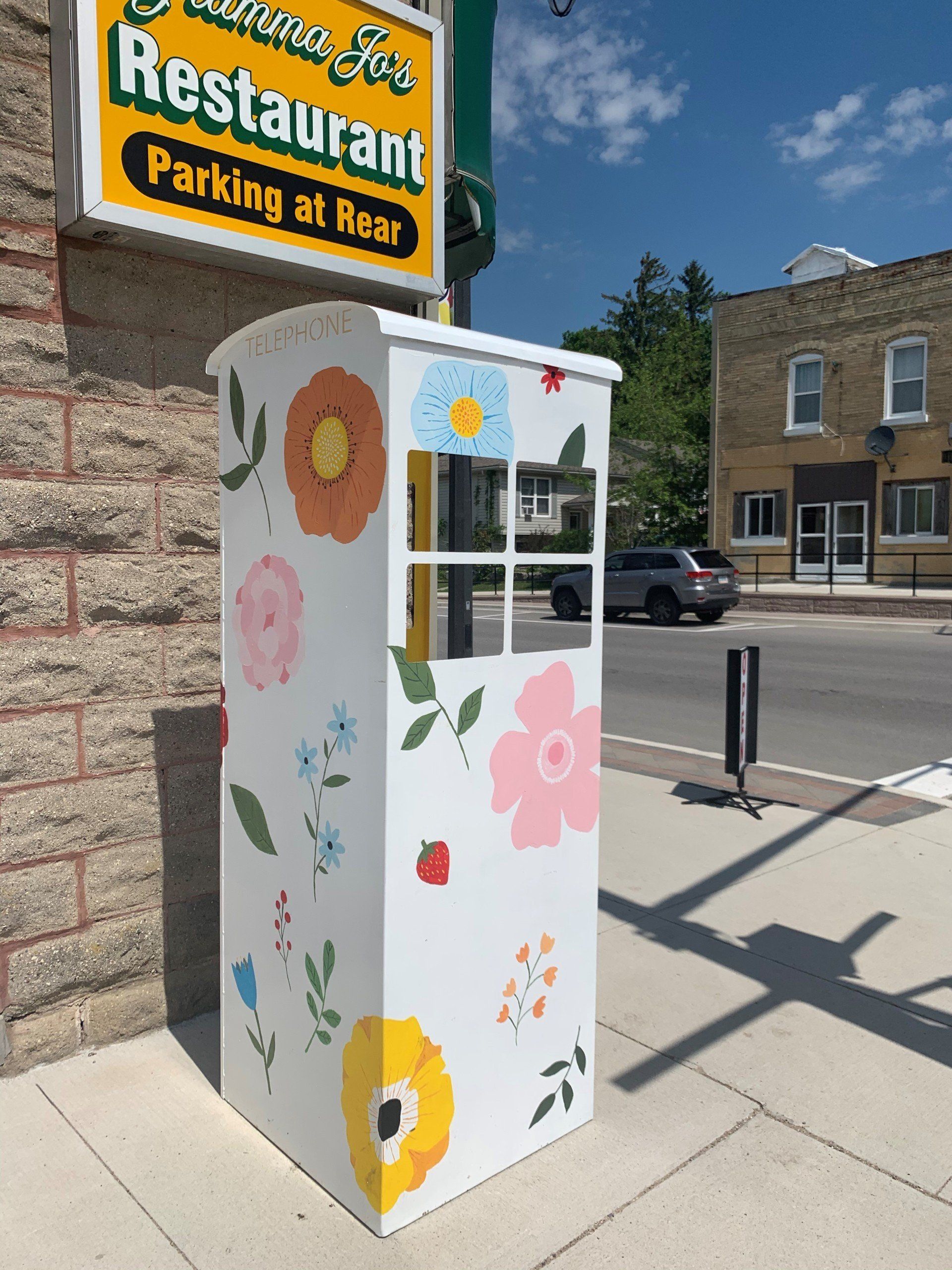 This booth was made for talking” mural – interactive art installation- white with flowers from back