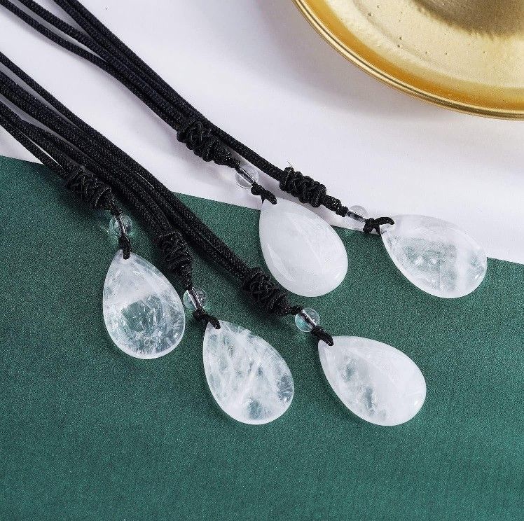 A necklace with three teardrop shaped beads on a black string