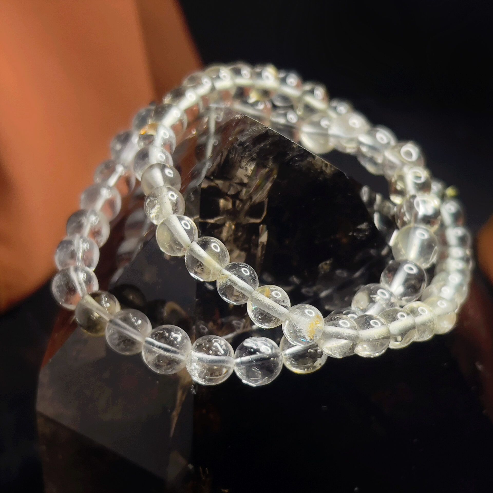 A close up of a bracelet made of clear beads