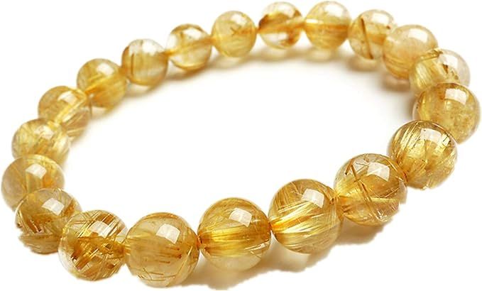 A close up of a bracelet with yellow beads on a white background.