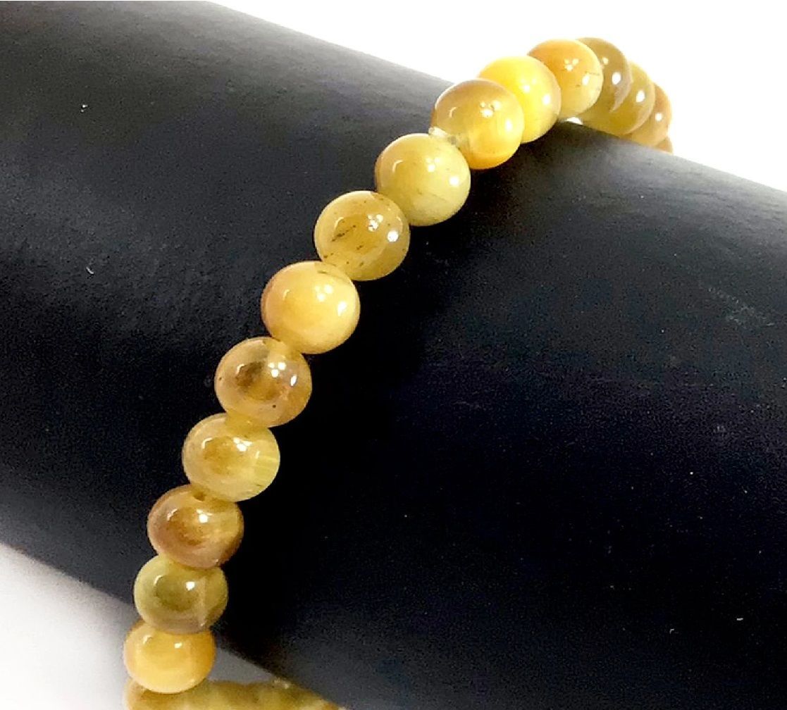 A close up of a bracelet with yellow beads on a person 's wrist