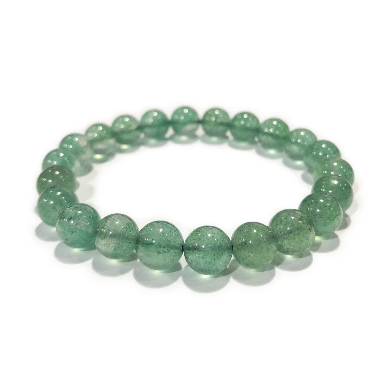 A bracelet made of green beads on a white surface.