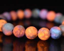 A bracelet with white beads on a black surface