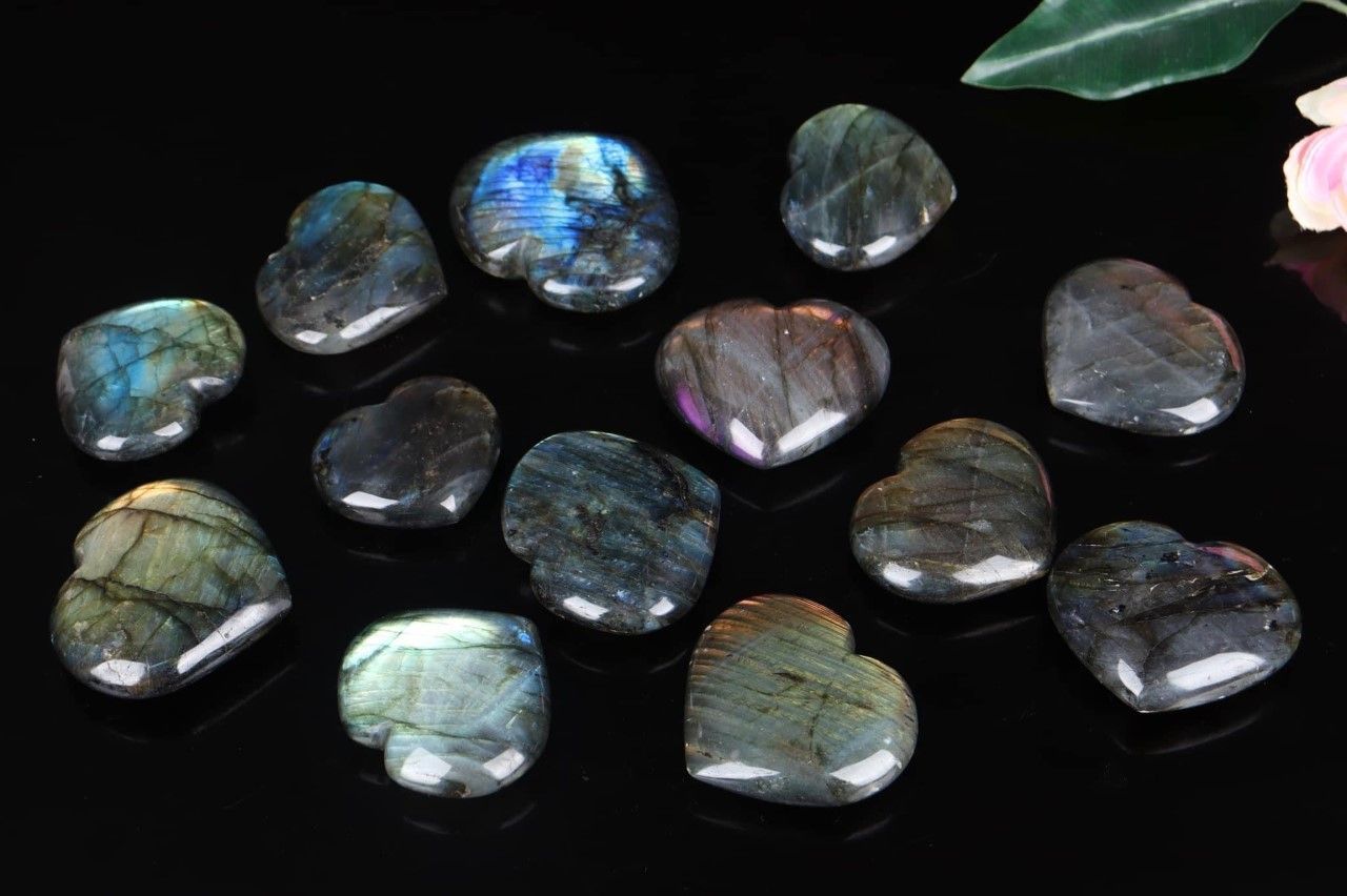 A group of heart shaped stones are sitting on top of each other on a black surface.