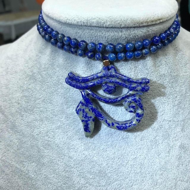 A close up of a necklace with a pendant on a mannequin.