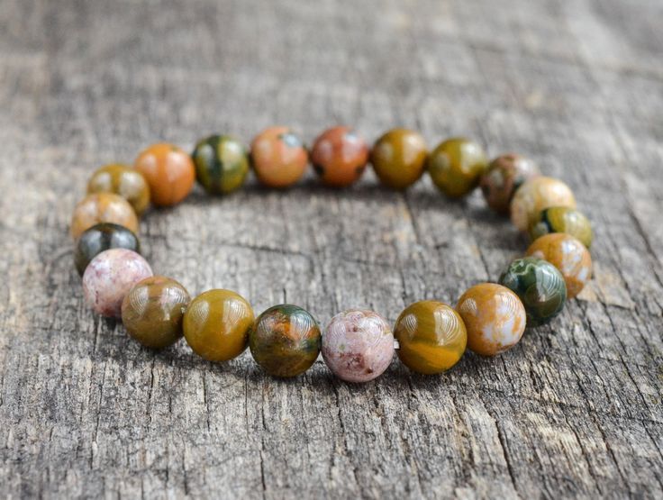 A bracelet made of colorful beads is sitting on a wooden table.