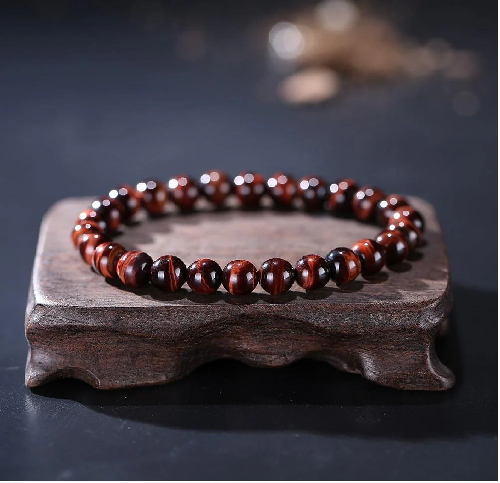 A close up of a bracelet made of brown beads on a wooden table.