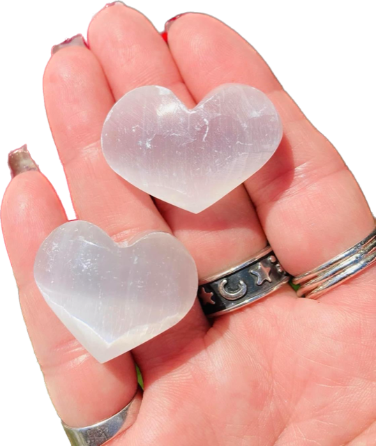 A person holding two heart shaped stones in their hand