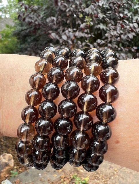 A bracelet made of brown beads is sitting on a wooden table.