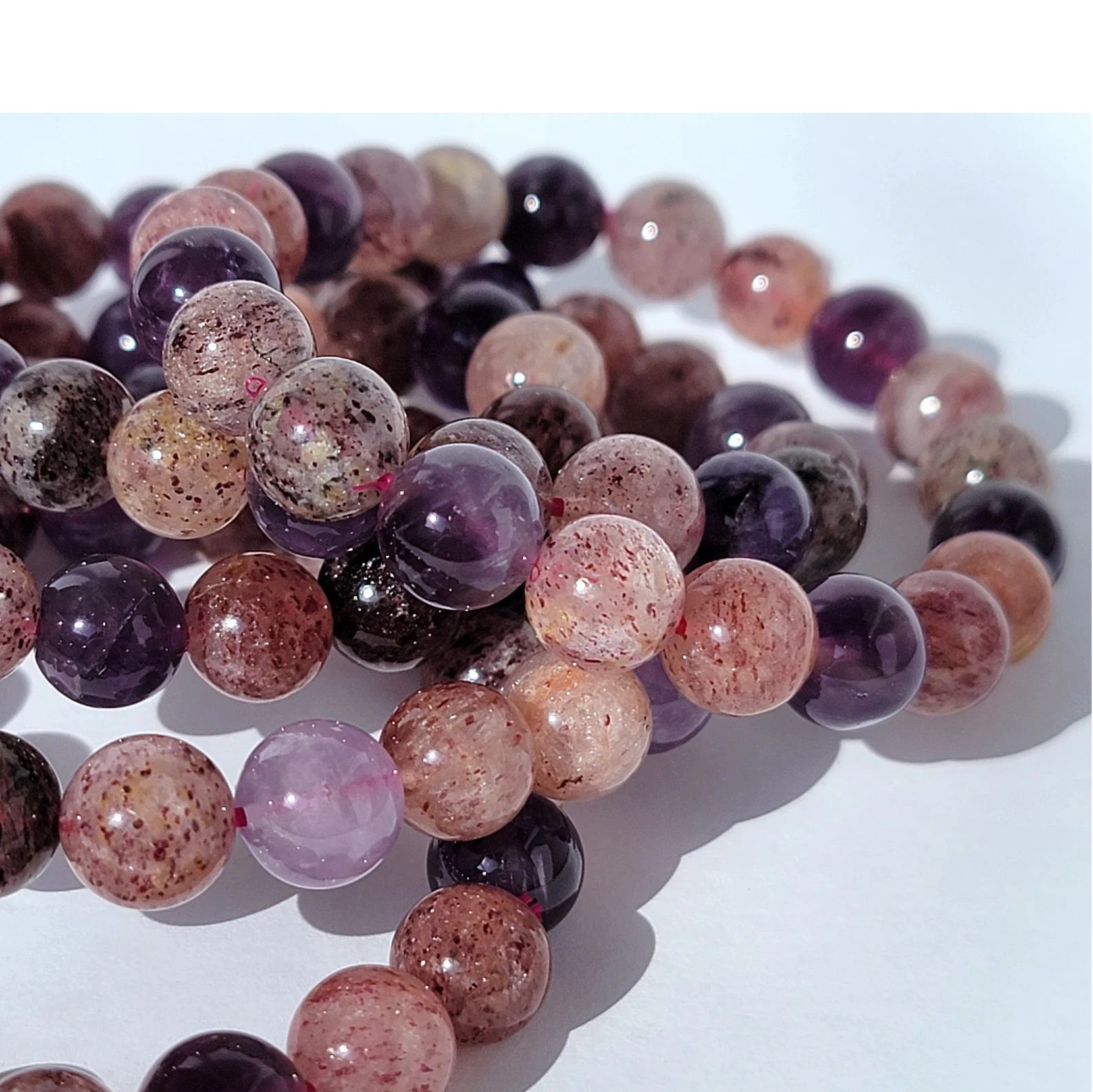 A string of clear and purple beads on a wooden surface