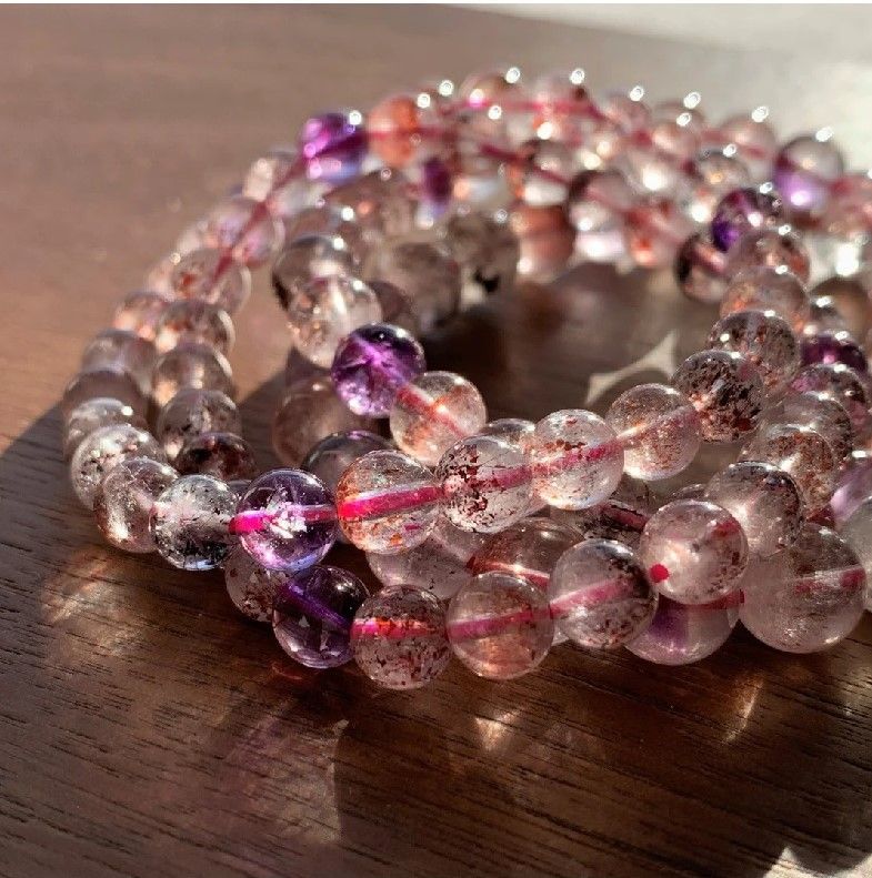 A string of clear and purple beads on a wooden surface