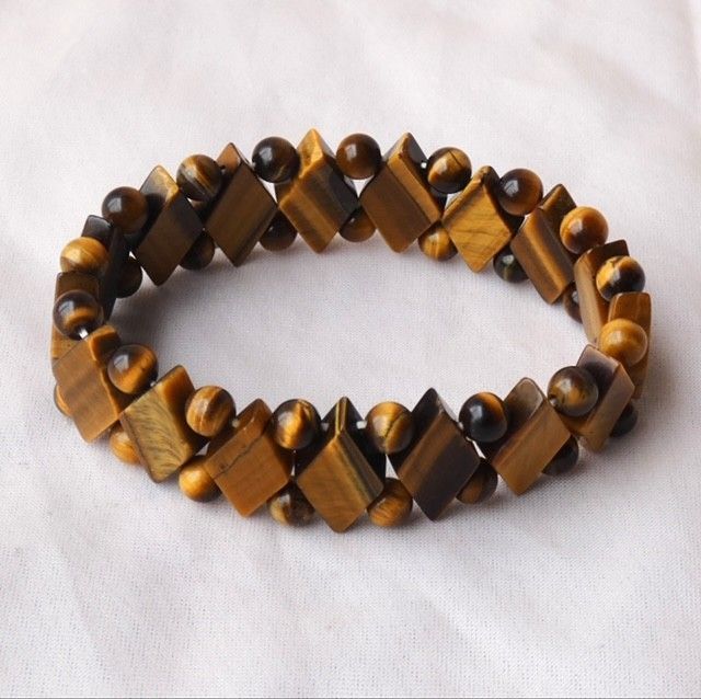 A bracelet made of tiger 's eye beads on a white surface