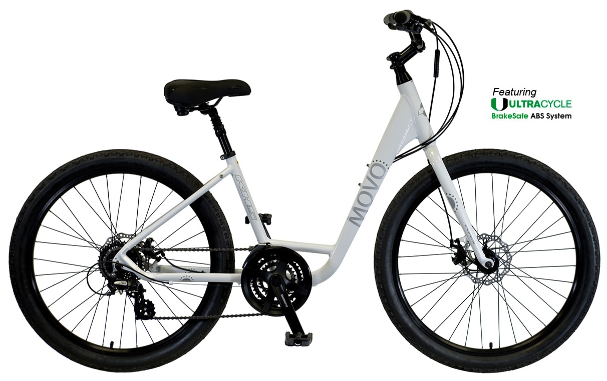 Blue bicycles parked on a lawn in front of a building with a tiled roof.