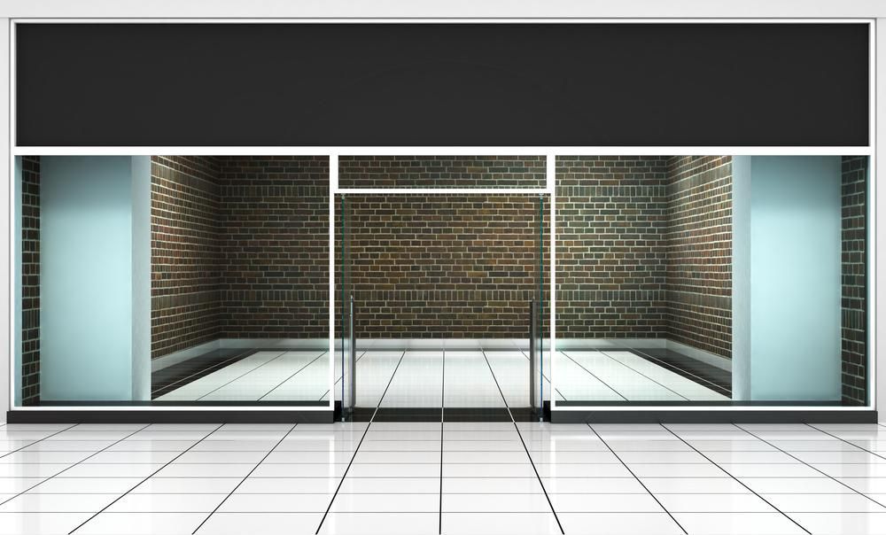 An Empty Store With a Brick Wall and Sliding Glass Doors — Headlands Glass in Ballina, NSW