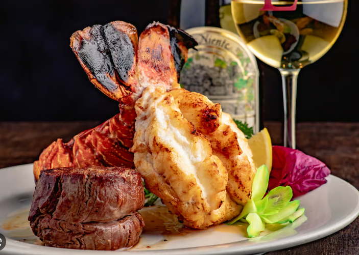 A plate of food with a glass of wine and a bottle of wine.