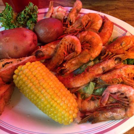 A plate of shrimp corn on the cob and potatoes