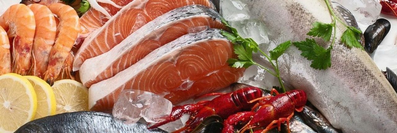 A variety of seafood is sitting on top of ice on a table.