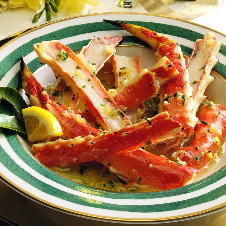 A plate of crab legs with a lemon wedge on top
