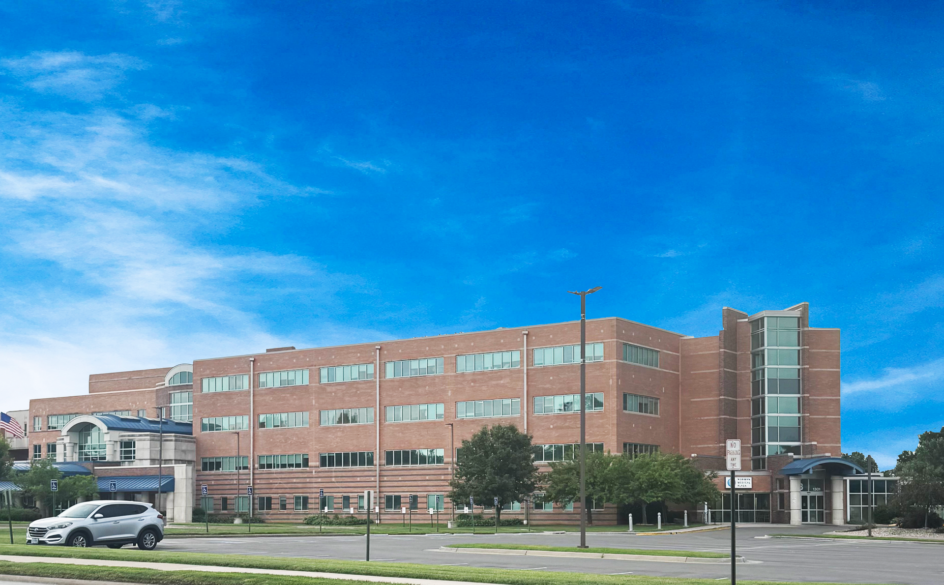 A large brick building with a sign that says Newman Hospital