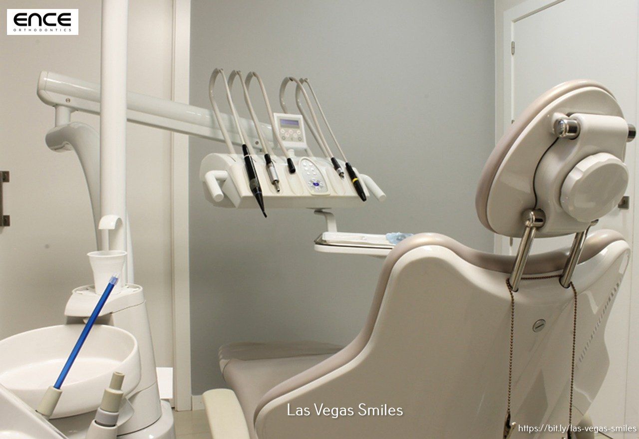 A dental chair in a dental office with the word ence on the wall