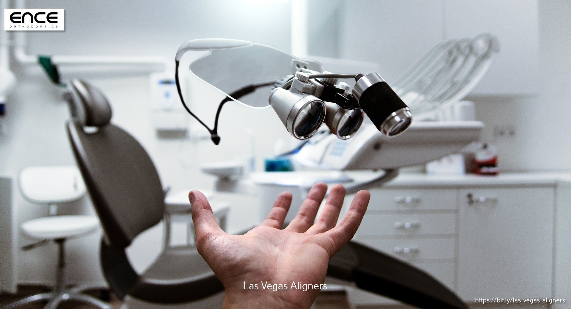 A person 's hand is reaching out towards a dental chair in a dental office.