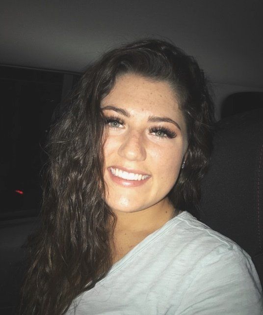 A woman with long hair is smiling for the camera.